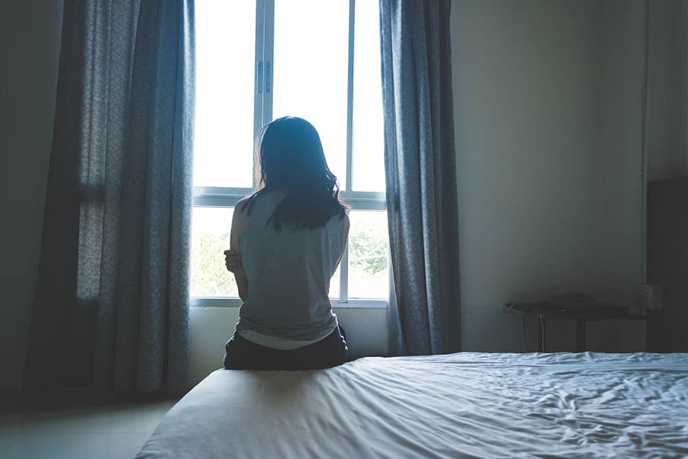 Female-sat-on-bed Female experiencing physical abuse